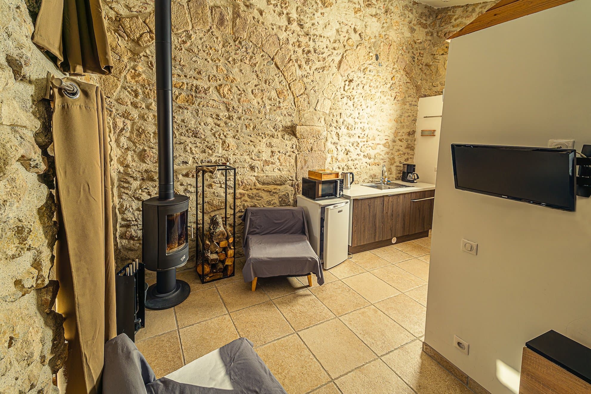 chambre étable au chateau de villelongue, avec le coin cuisine et le poële à bois, au chateau de villelongue, gîte et chambres d'hôtes